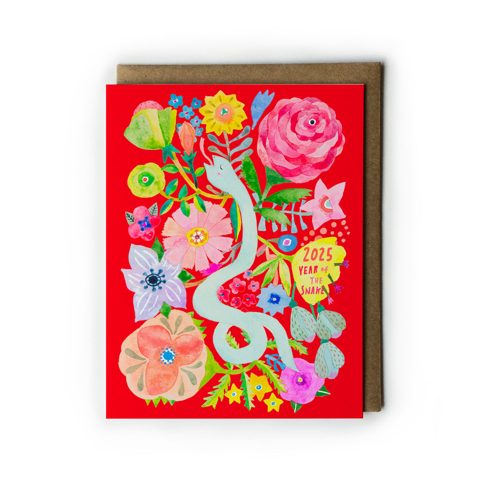 Vibrant 2025 Year of the Snake holiday card featuring colorful watercolor illustration of a white snake surrounded by diverse flowers on a bright red background, with kraft envelope