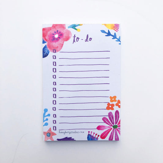 Colorful floral to-do list notepad with watercolor flowers in pink, red, and blue. Features blank lines for tasks and decorative flower illustrations around the edges.