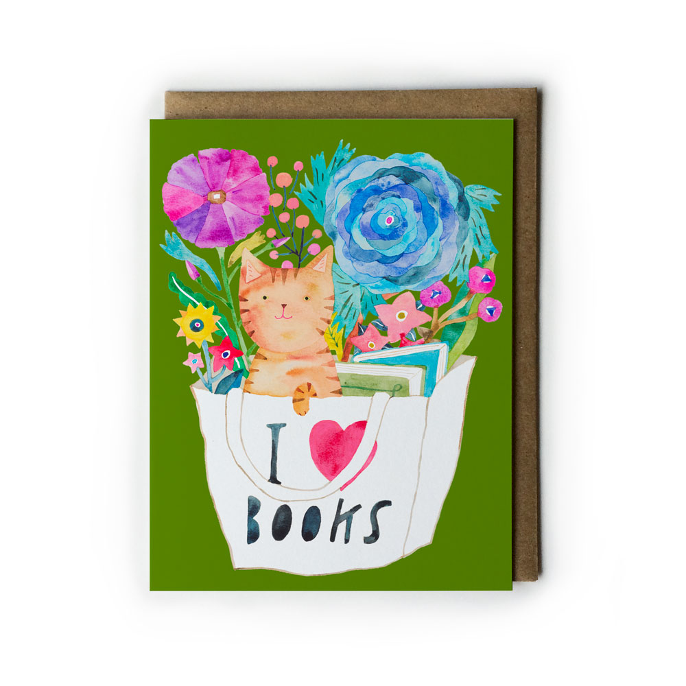 Watercolor greeting card featuring orange tabby cat in "I love books" tote bag surrounded by vibrant flowers, on green background with kraft envelope