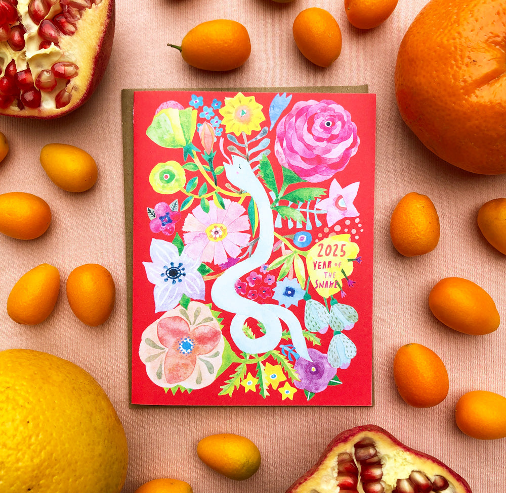 Vibrant 2025 Year of the Snake holiday card featuring colorful floral illustration, surrounded by fresh citrus fruits and pomegranate on a peach background, showcasing festive and seasonal design for Chinese New Year celebration