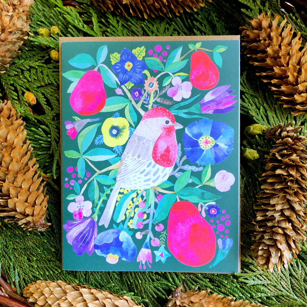 Vibrant holiday greeting card featuring colorful watercolor illustration of a house finch surrounded by red pears, flowers, and foliage on a teal background, displayed on pine branches with pinecones