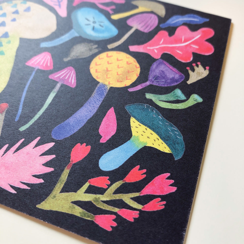 Colorful watercolor illustration of various mushroom types and forest elements on a black background greeting card, showcasing vibrant hues and whimsical designs