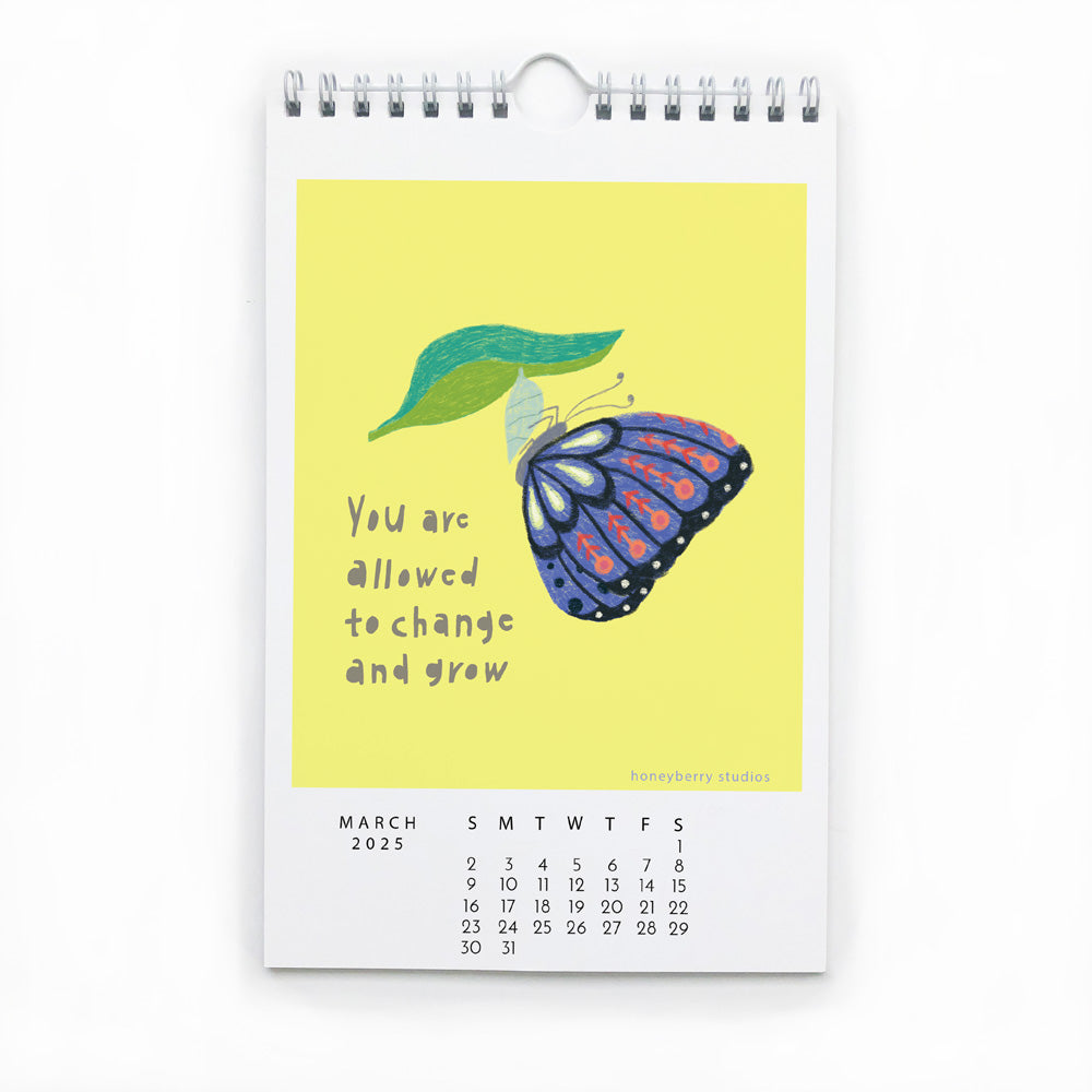 2025 wall calendar page for March featuring colorful butterfly illustration on yellow background with inspirational quote "You are allowed to change and grow" and monthly date grid