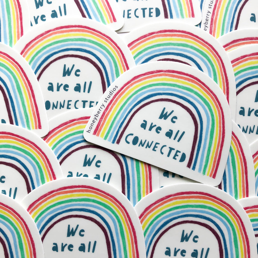 Colorful vinyl stickers featuring vibrant rainbow designs with the hand-lettered text "We are all connected" in teal. Multiple stickers are shown overlapping, showcasing the 3-inch size and weather-resistant quality of these USA-made products.