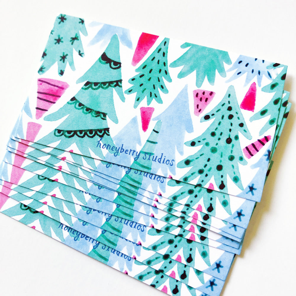 Colorful watercolor Christmas tree pattern on tiny note cards, stacked to show design of playful abstract holiday forest in shades of teal, pink, and blue