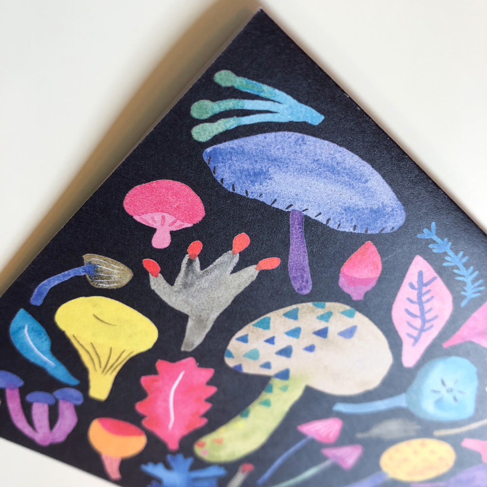 Colorful watercolor mushroom illustration on greeting card, featuring vibrant fungi in various shapes and sizes, with decorative leaves and patterns on dark background
