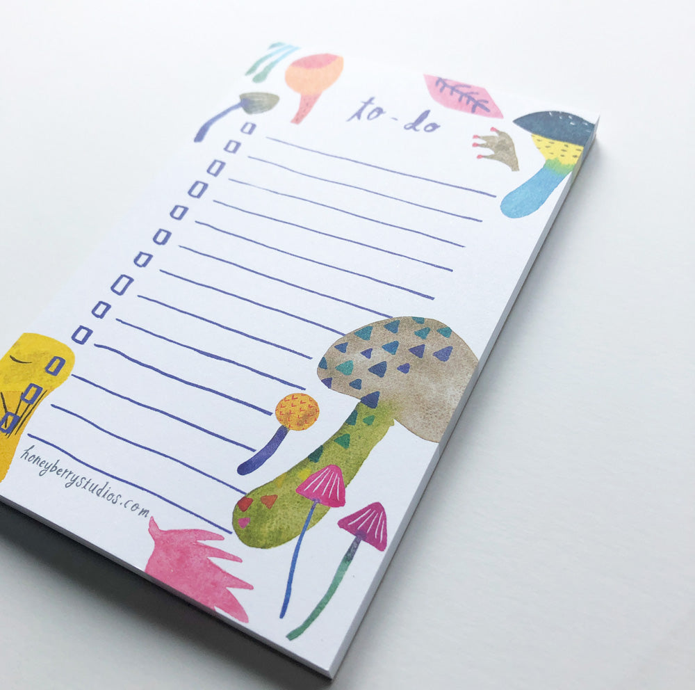 Colorful mushroom-themed to-do list notepad with watercolor illustrations, featuring lined paper for tasks and whimsical fungi designs along the borders