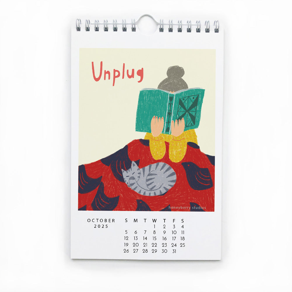 Colorful illustration for October 2025 calendar page featuring person reading book with cat, encouraging to 'Unplug'. Wire-bound wall calendar with inspirational artwork and monthly dates.