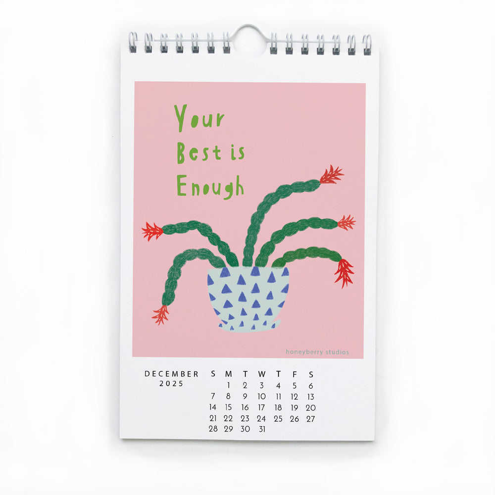 2025 wall calendar page for December showing a colorful illustration of a potted plant with the inspirational message "Your Best is Enough" on a pink background, demonstrating the product's uplifting and joyful design