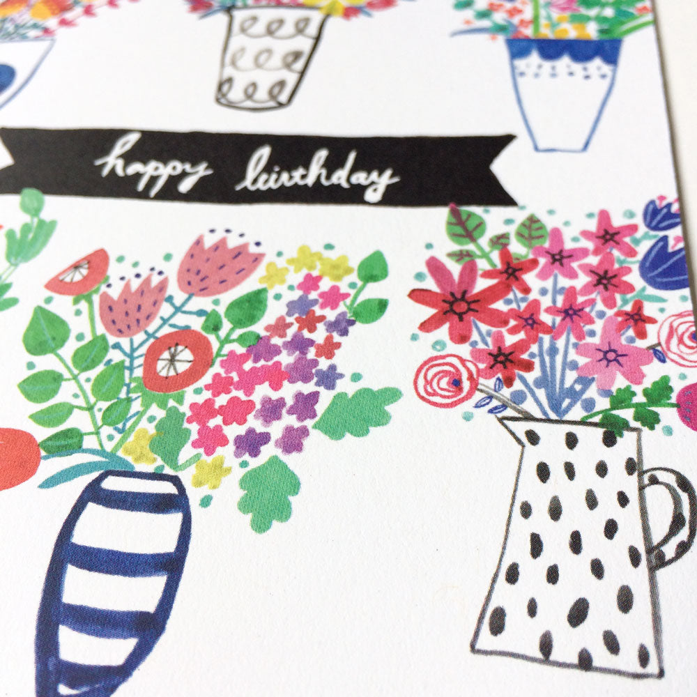 Colorful spring bouquet birthday card featuring hand-drawn flowers in various vases and pots, with a black banner saying 'happy birthday' in white script