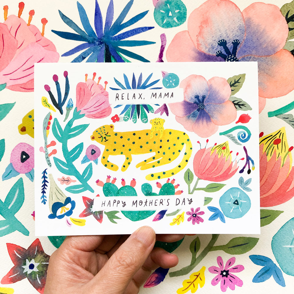 Colorful watercolor Mother's Day card featuring a yellow spotted cheetah surrounded by vibrant flowers and leaves, with text saying "Relax, Mama" and "Happy Mother's Day" held against a floral background